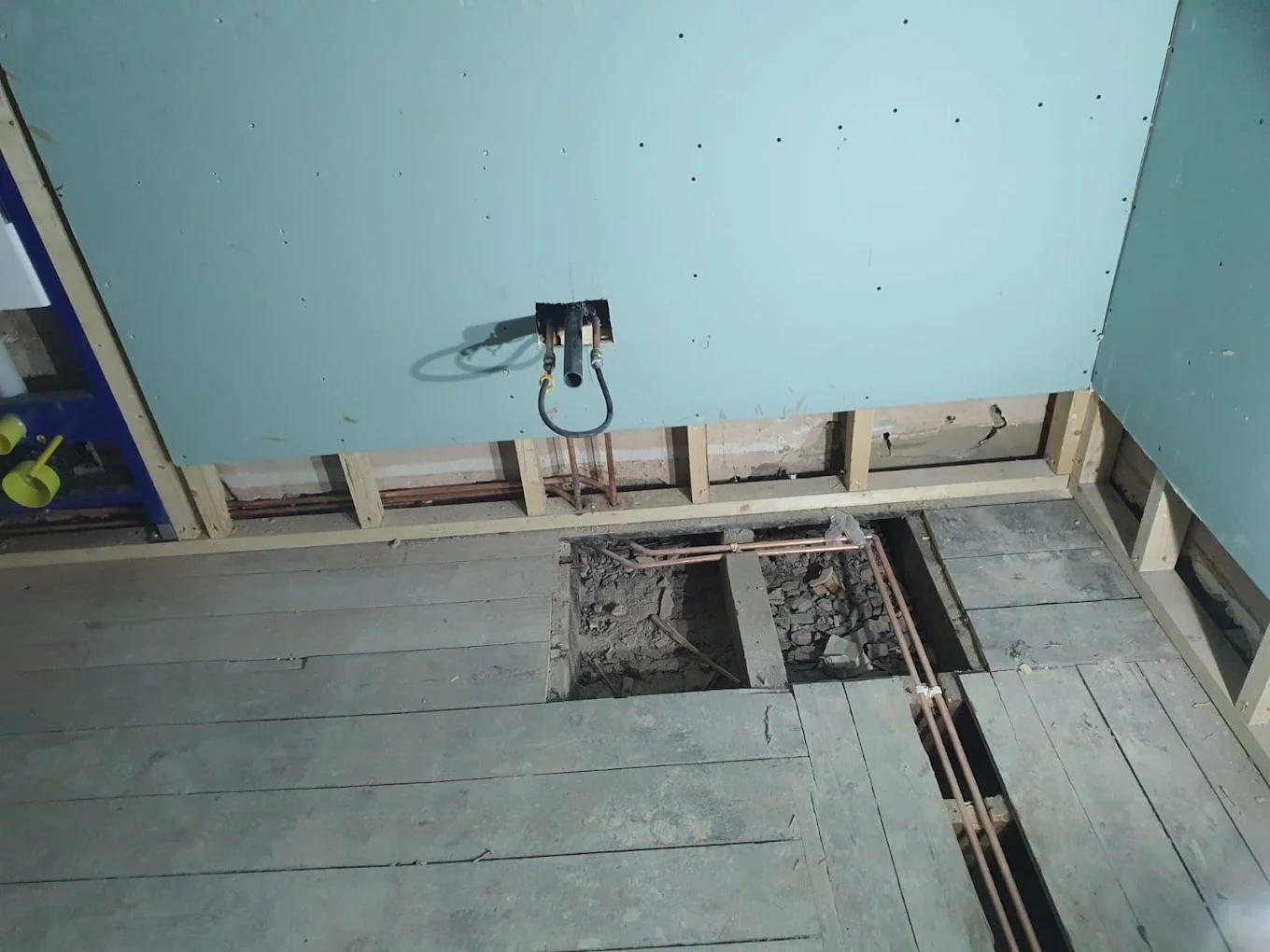 Wall-mounted water heating equipment and associated piping